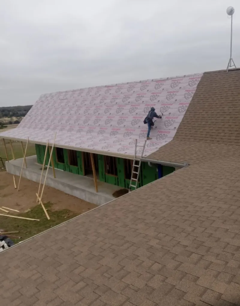 Worker preparing underlayment for a metal roof installation in Castaic